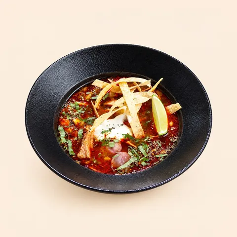Red pozole soup with tortilla strips