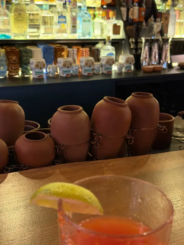 Clay pots on the bar and a cocktail with lime